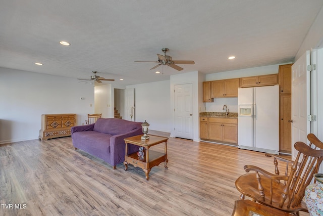 living area with baseboards, recessed lighting, stairs, and light wood-style floors