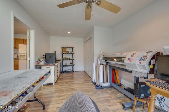 interior space with light wood-type flooring, a textured ceiling, and recessed lighting