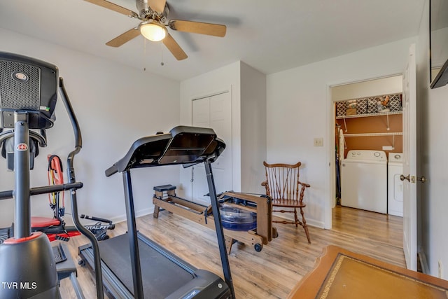 exercise area featuring baseboards, wood finished floors, a ceiling fan, and washer and dryer