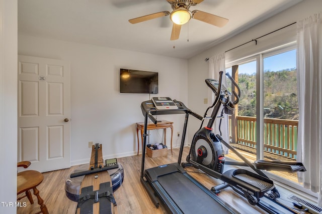 workout room featuring a ceiling fan, baseboards, and wood finished floors