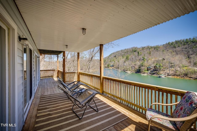 deck featuring a water view and a view of trees