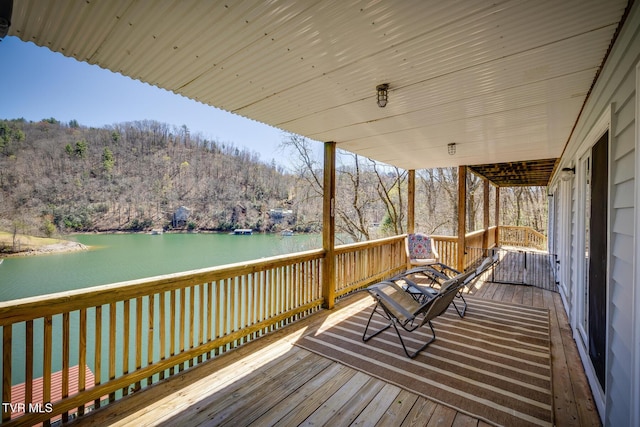 deck with a water view and a forest view