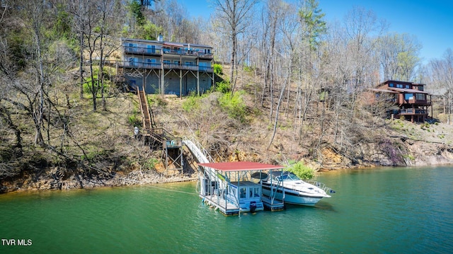 dock area featuring a water view, stairs, and a view of trees