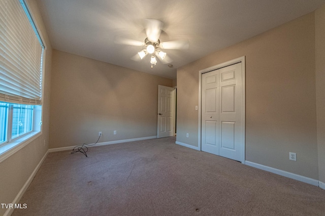 unfurnished bedroom featuring a closet, carpet flooring, a ceiling fan, and baseboards