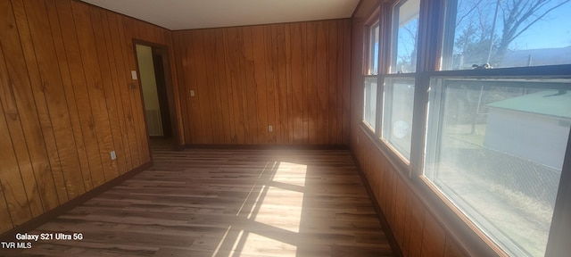 spare room with wooden walls and wood finished floors