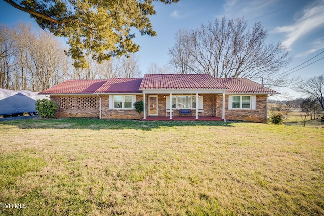 ranch-style home featuring metal roof, brick siding, a porch, and a front yard