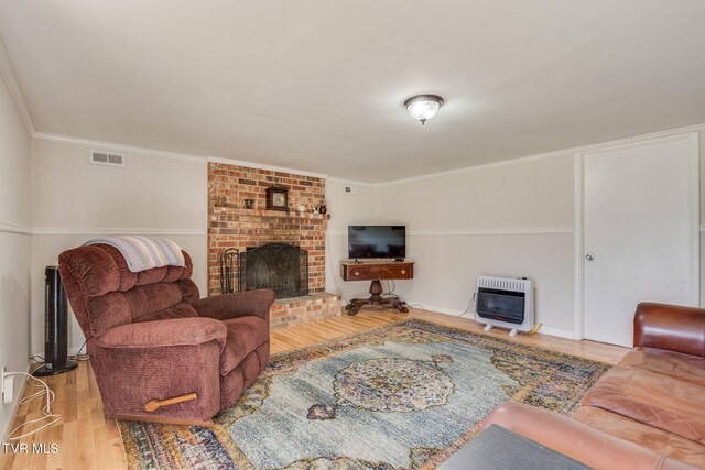 1545 Old State Route 34, Telford, TN 37690 - living room with visible vents, a brick fireplace, ornamental molding, wood finished floors, and heating unit