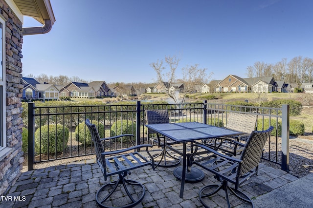 view of patio / terrace featuring outdoor dining space and a residential view