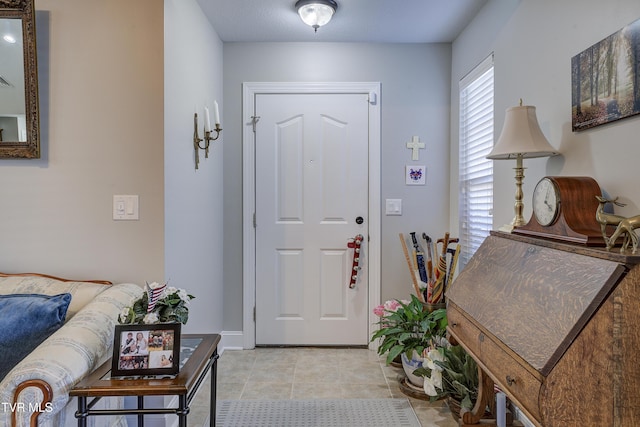 foyer entrance featuring light tile patterned floors and baseboards