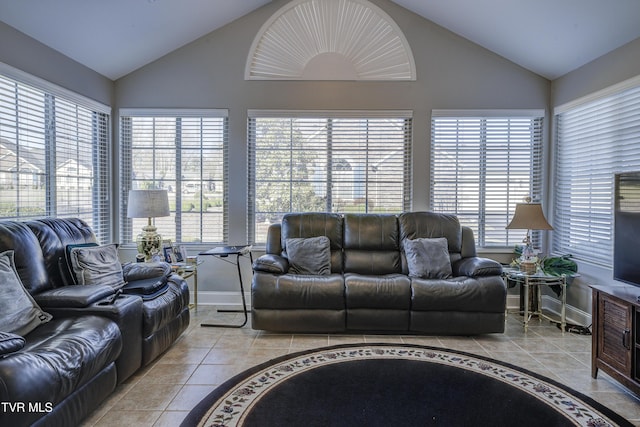 living room with lofted ceiling, plenty of natural light, baseboards, and light tile patterned floors