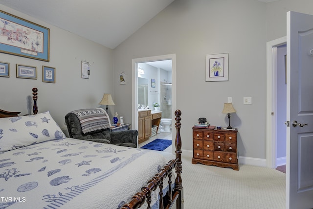 bedroom with vaulted ceiling, carpet floors, connected bathroom, and baseboards