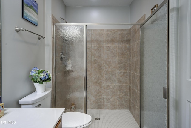 bathroom with a stall shower, vanity, and toilet