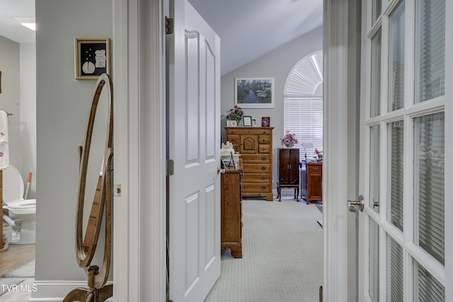 hall featuring vaulted ceiling and carpet