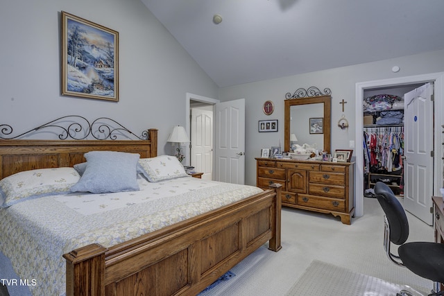 bedroom featuring a closet, light carpet, vaulted ceiling, and a spacious closet