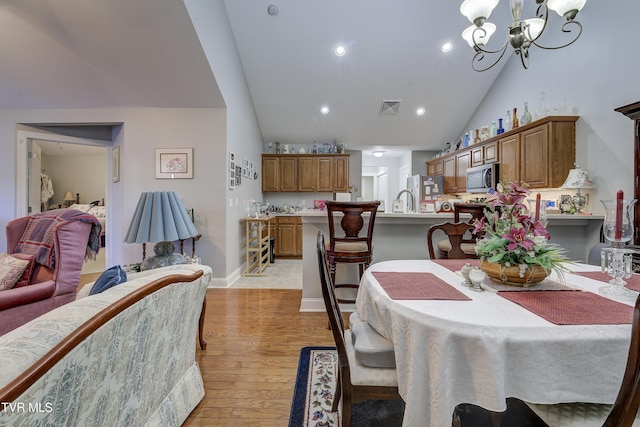 dining area featuring high vaulted ceiling, recessed lighting, visible vents, a chandelier, and light wood-type flooring