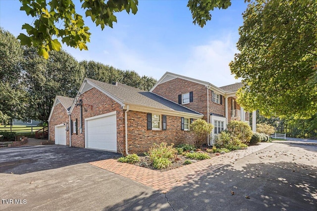 view of front of home featuring aphalt driveway, brick siding, fence, and an attached garage