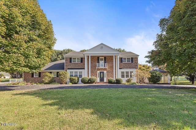 greek revival house with a front lawn and brick siding