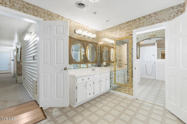 full bath with visible vents, wallpapered walls, vanity, a walk in shower, and tile patterned floors