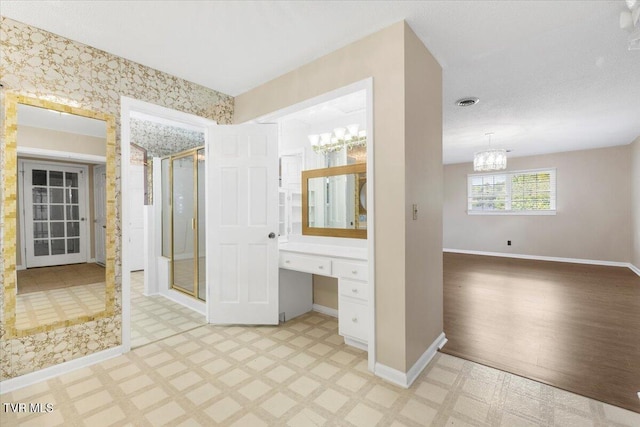 full bath featuring visible vents, baseboards, tile patterned floors, a shower stall, and a notable chandelier