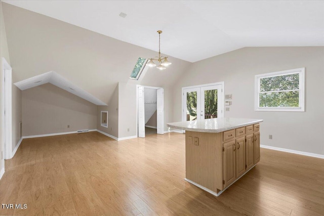 kitchen with light wood-type flooring, french doors, light countertops, and vaulted ceiling