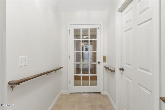 doorway to outside featuring light tile patterned floors and baseboards