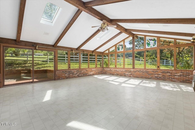 interior space with ceiling fan and lofted ceiling with skylight