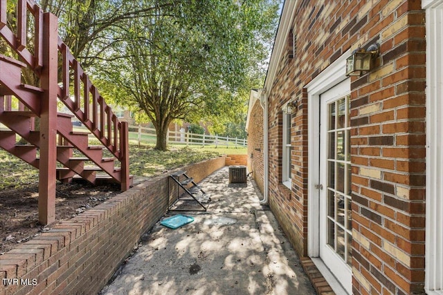 view of patio with stairs, cooling unit, and fence