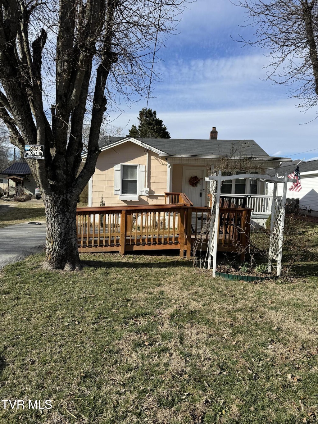 view of front of property with a front yard and a wooden deck