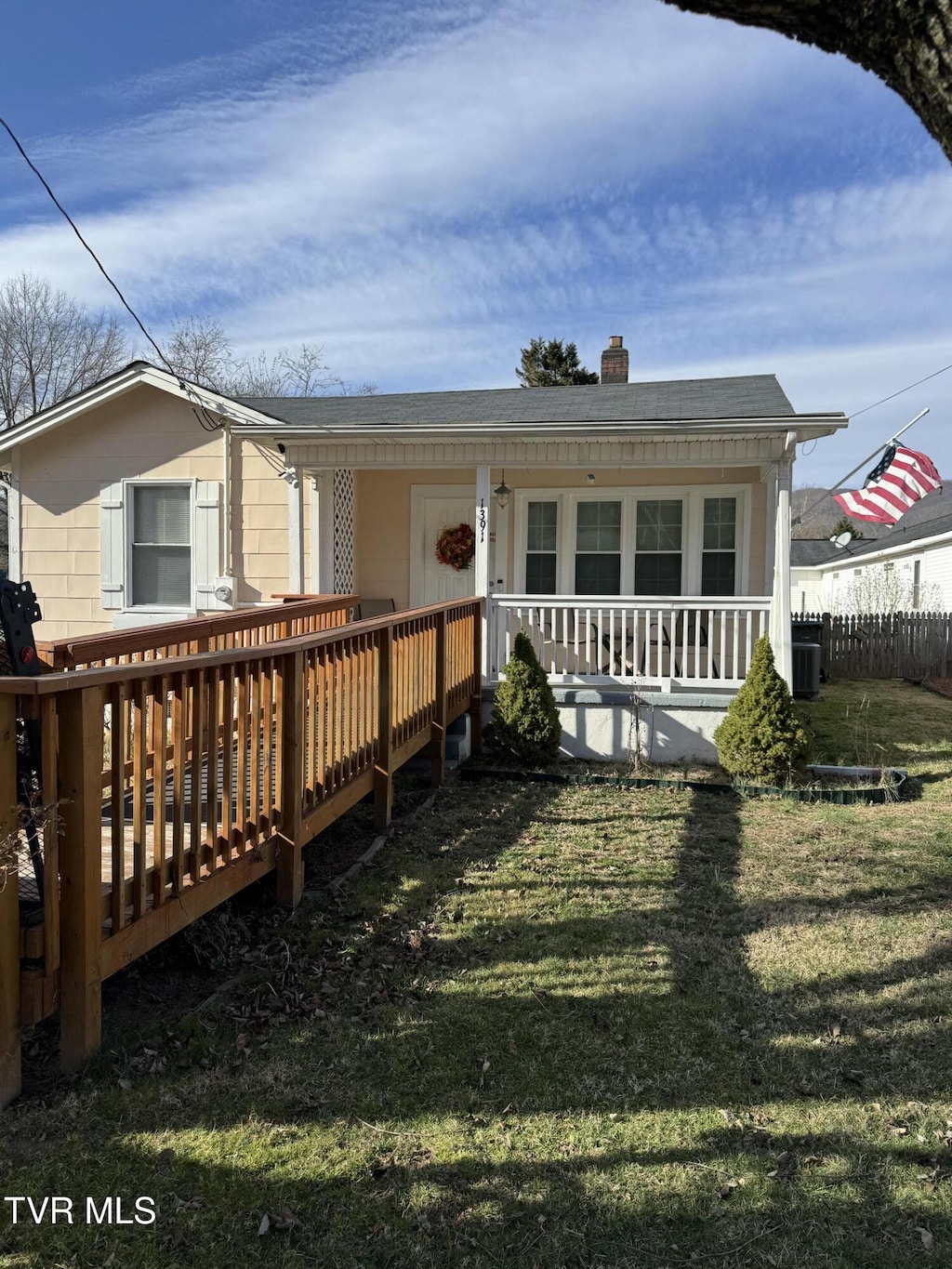 view of front of home with roof with shingles, a front lawn, a chimney, and central air condition unit