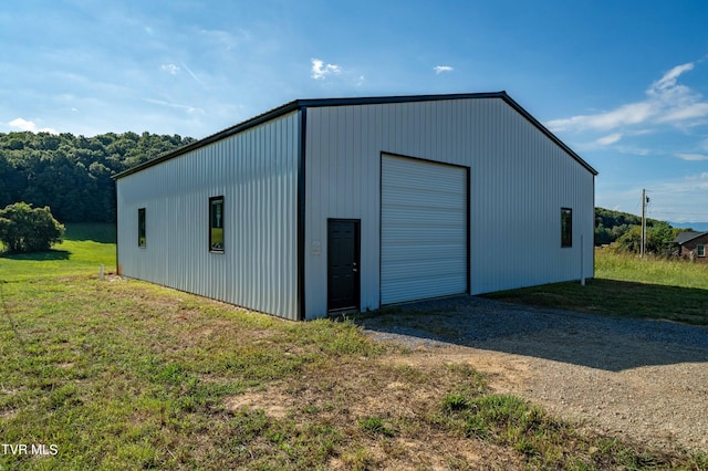 view of pole building featuring a yard and gravel driveway