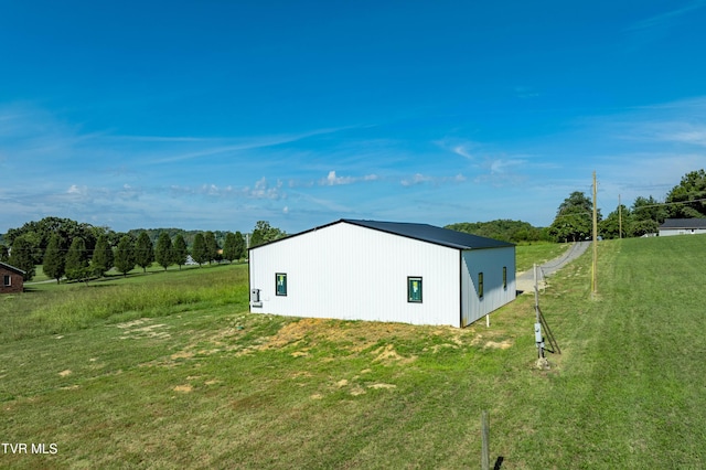 view of home's exterior featuring a lawn and an outbuilding