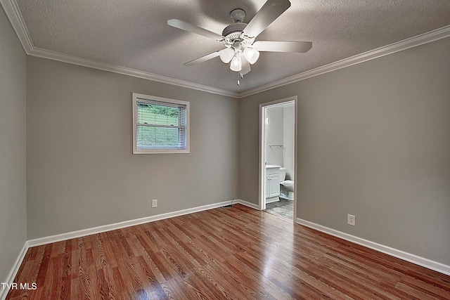 unfurnished room with baseboards, wood finished floors, and crown molding