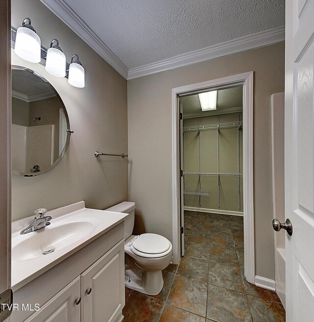 bathroom featuring toilet, ornamental molding, a textured ceiling, and vanity