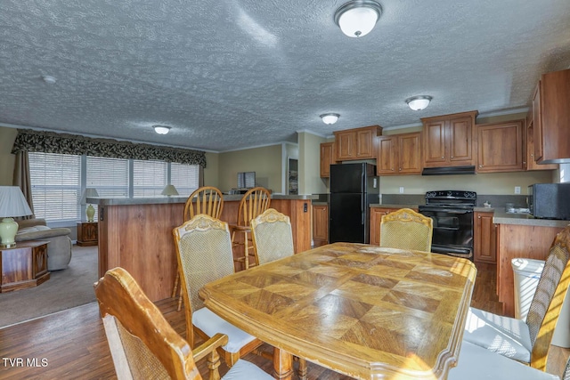 dining area with a textured ceiling and wood finished floors