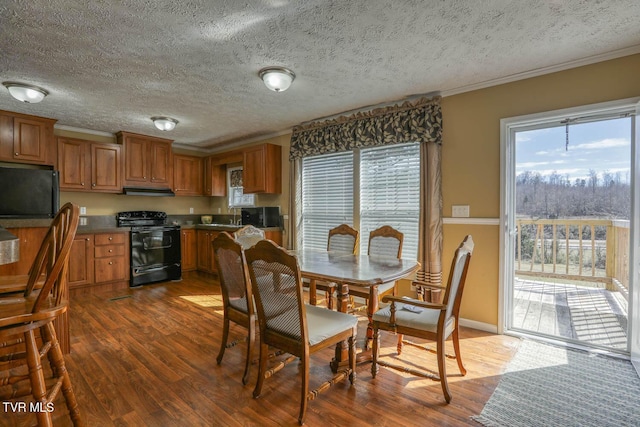 dining area with crown molding, a textured ceiling, and dark wood-style flooring