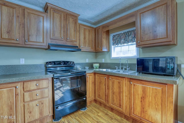 kitchen with a textured ceiling, under cabinet range hood, a sink, light wood-style floors, and black appliances