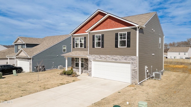 craftsman-style house with a garage, stone siding, driveway, and central air condition unit