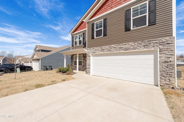 view of front of house with a garage, stone siding, and concrete driveway