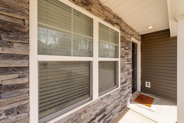 property entrance featuring stone siding and a porch