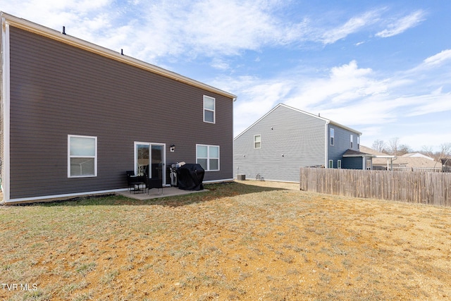 rear view of house featuring a patio area, fence, and a yard