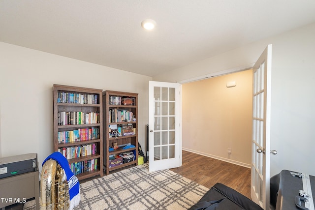 interior space with french doors, wood finished floors, and baseboards