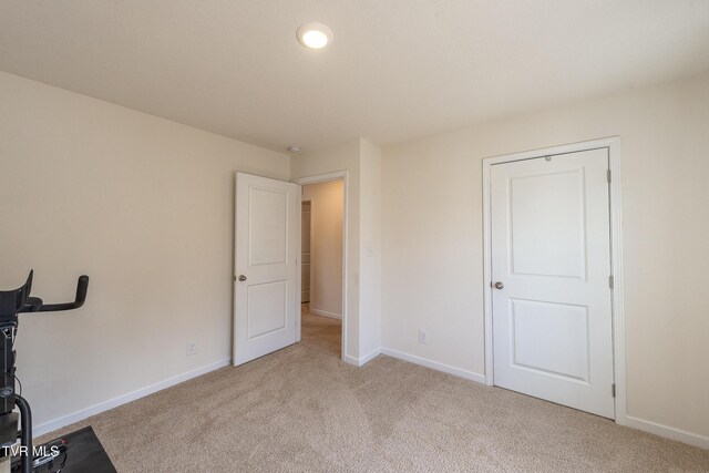 interior space with baseboards and light colored carpet