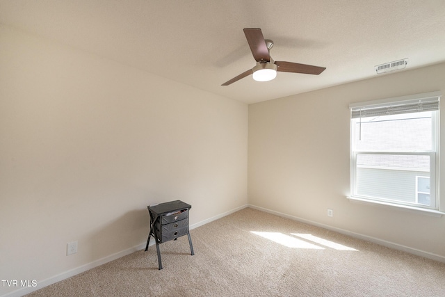 spare room featuring baseboards, visible vents, ceiling fan, and carpet flooring