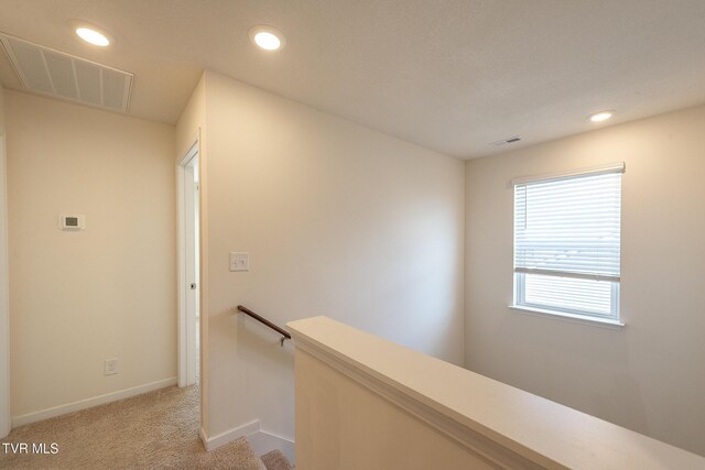 hall featuring light carpet, recessed lighting, visible vents, and an upstairs landing