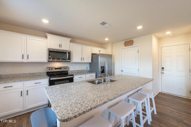 kitchen featuring visible vents, stainless steel appliances, white cabinetry, a sink, and recessed lighting