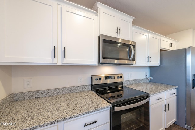 kitchen featuring white cabinets, light stone countertops, and stainless steel appliances