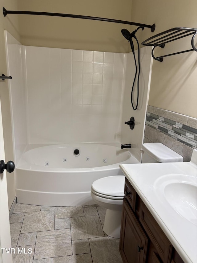 bathroom featuring vanity, a combined bath / shower with jetted tub, toilet, and tile walls