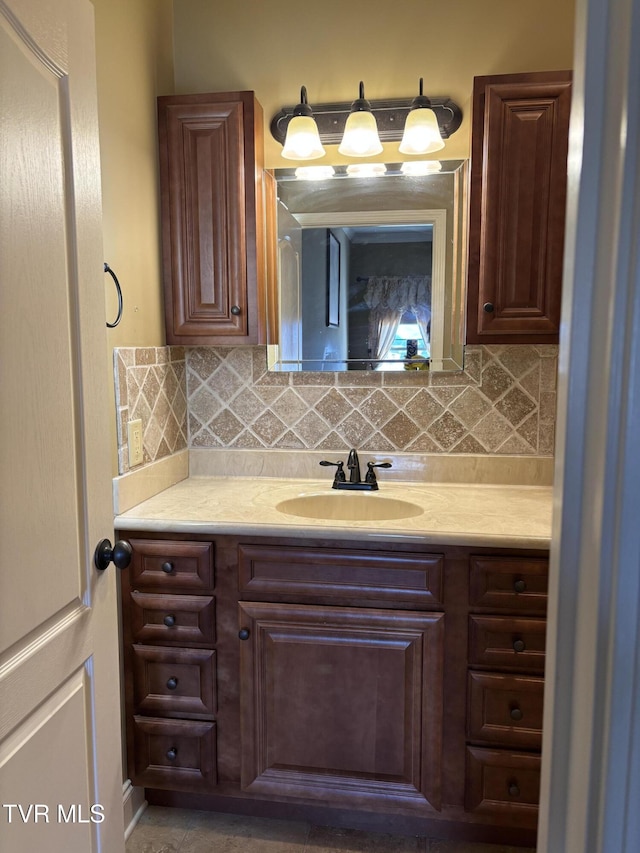 bathroom with tasteful backsplash and vanity