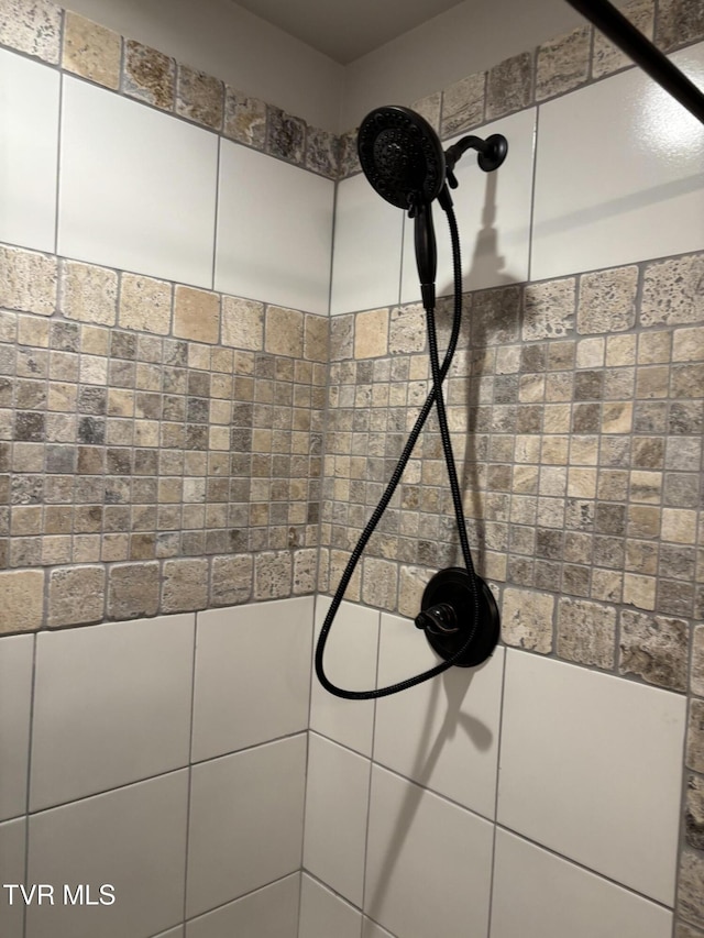 interior details featuring tiled shower