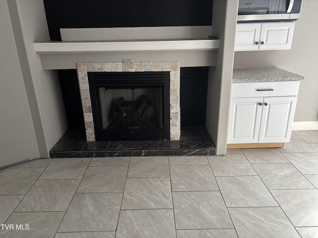 details featuring stainless steel microwave and a tile fireplace